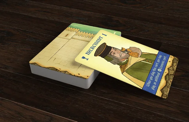 A Crown of Aragón Merchant card resting across the draw deck on a dark wooden table.