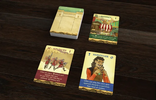 Crown of Aragón draw deck, play mat, and Market, Soldiers, and Saboteur cards arranged on a dark wooden table.